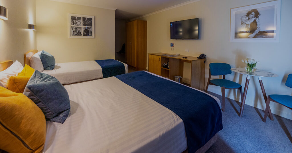 Inviting twin room in Wrest Point's Motor Inn, Hobart, with neutral tones and soft lighting, ideal for relaxation.
